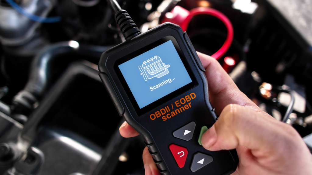 mechanik podłączający tester diagnostyczny do gniazda obd2