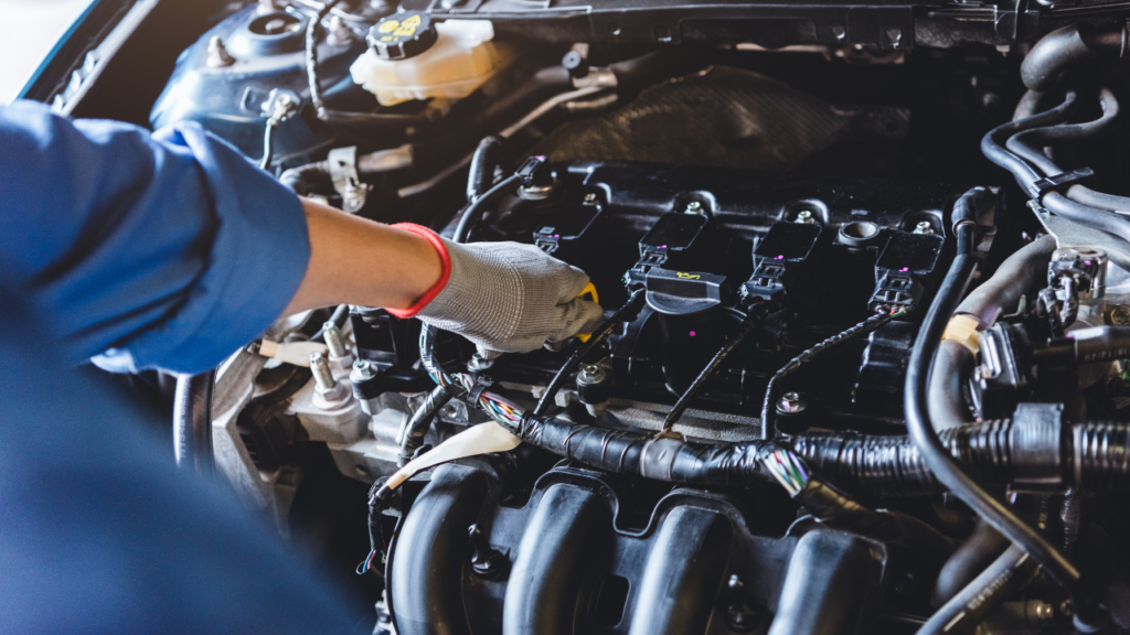 zbliżenie na dłonie mechanika pracującego przy elementach silnika (2)