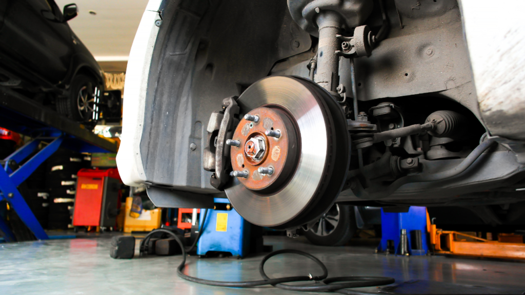 zbliżenie na nową tarczę hamulcową zamontowaną w kole samochodu.